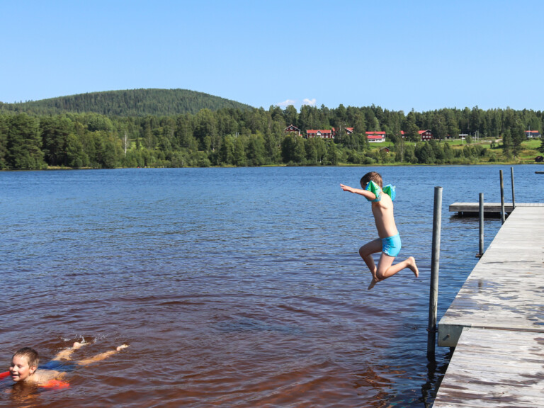 Pojke hoppar från badbrygga