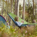 Kompisar vilar i hängmatta i naturen