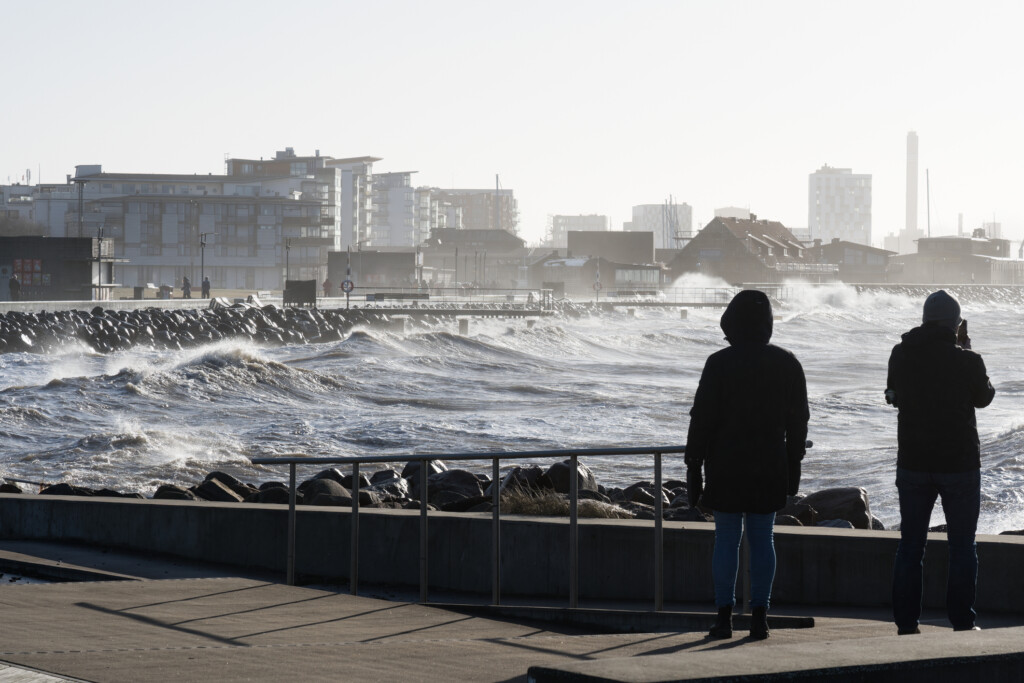 Två personer tittar på en storm på havet