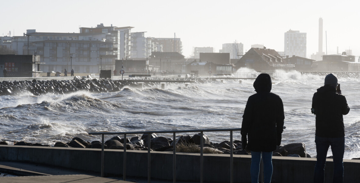 Två personer tittar på en storm på havet
