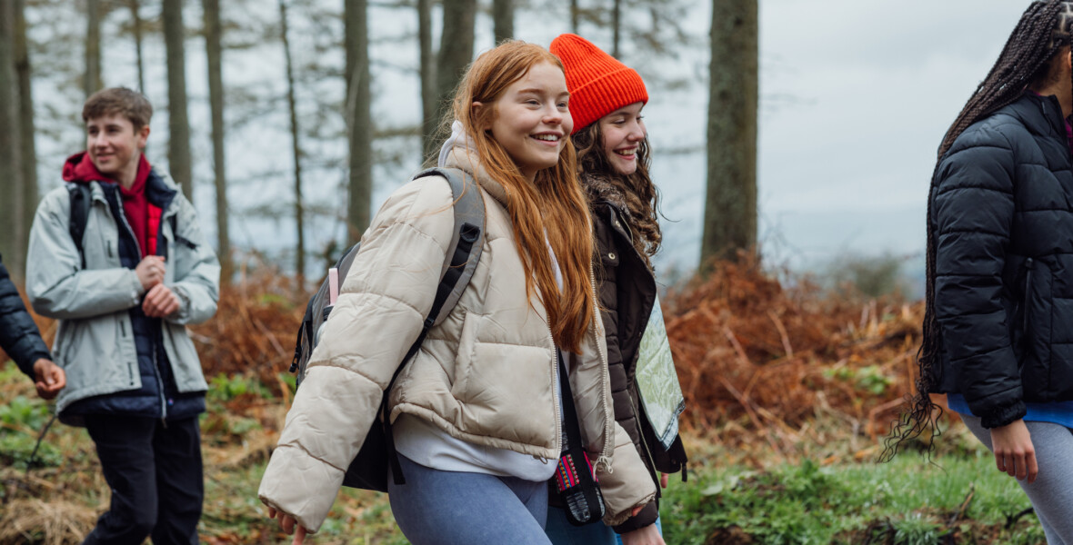 Ungdomar går i skogsmiljö