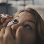 Kvinna tar ögondroppar