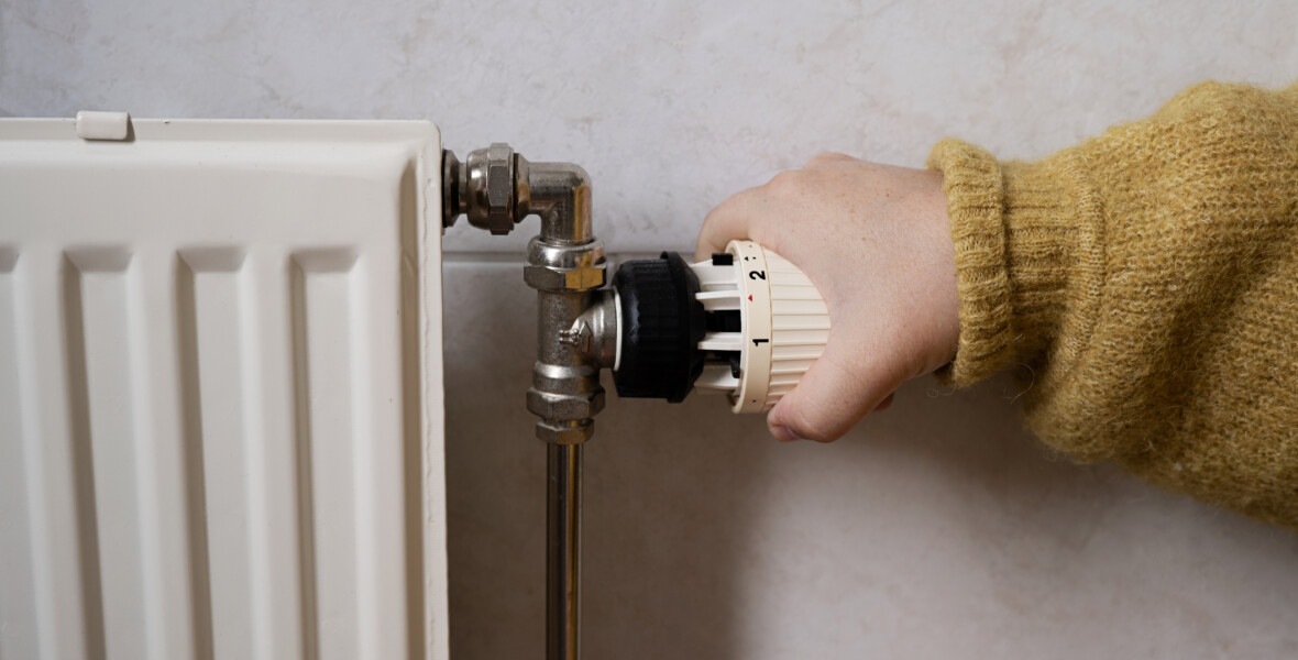 Hand skruvar ner värmen på element