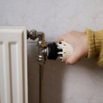 Hand skruvar ner värmen på element