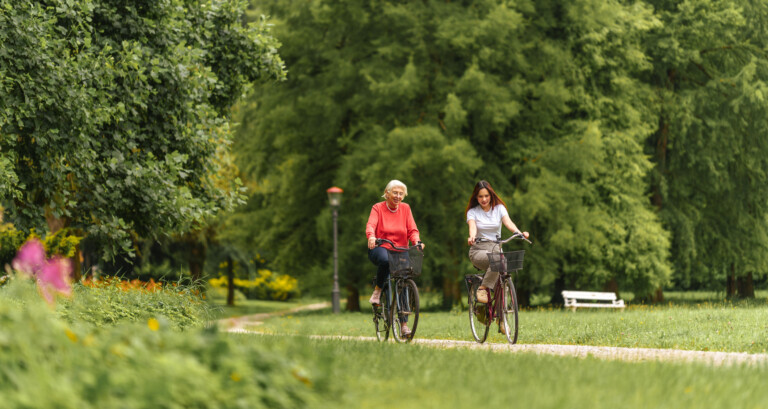 Två personer cyklar i en park