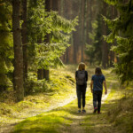 Två personer går i skog