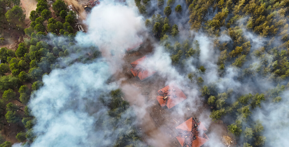 Rök från en skogsbrand sprider sig över bostadshus