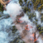 Rök från en skogsbrand sprider sig över bostadshus